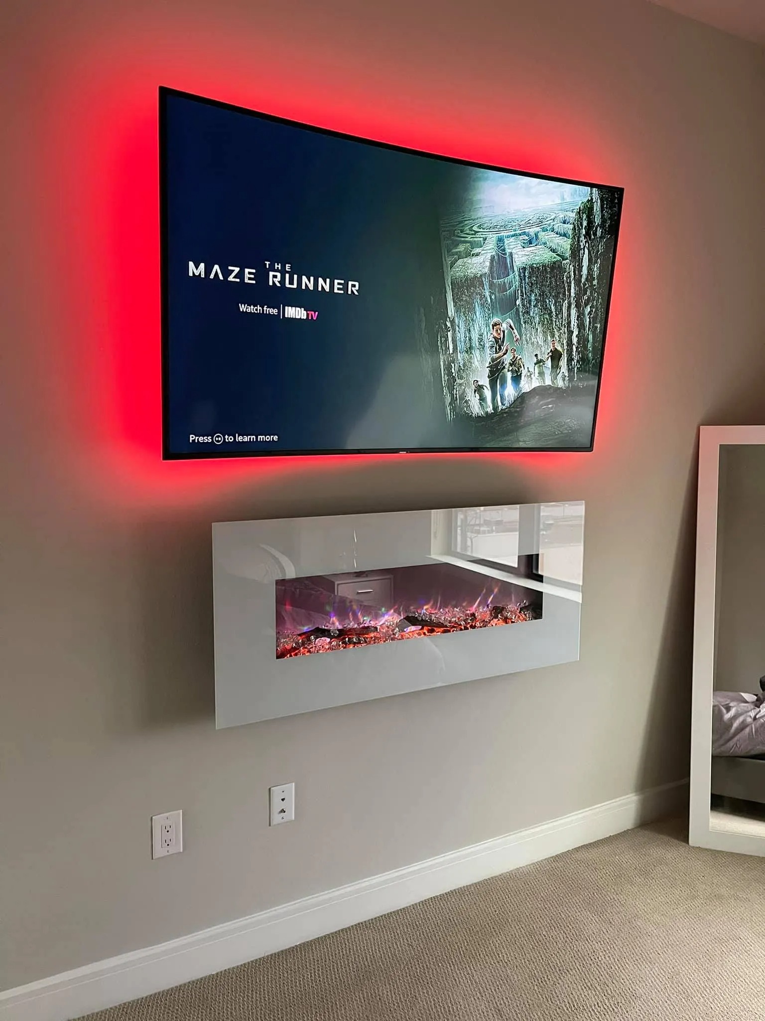 TV mounted above electric fireplace with recessed cable routing — Twin Cities install